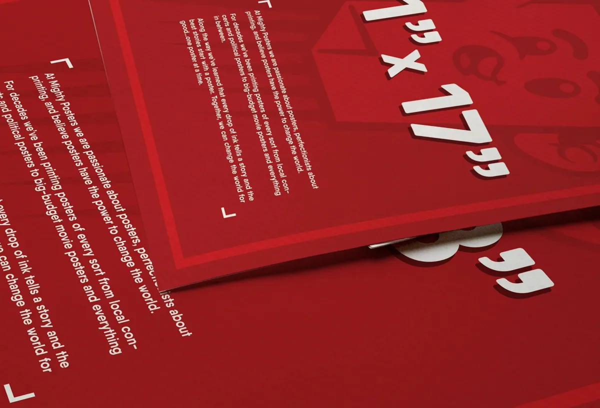 Two red posters overlapping on a table, one marked 11 by 17